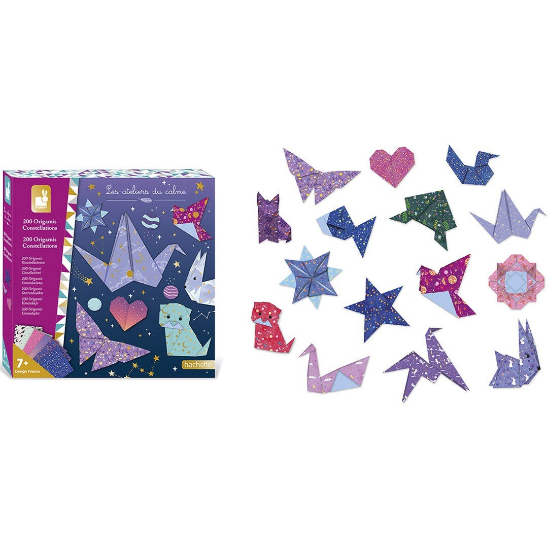 Janod origami set verpakking naast een collectie van gevouwen figuren met sterrenbeeldenpatronen.