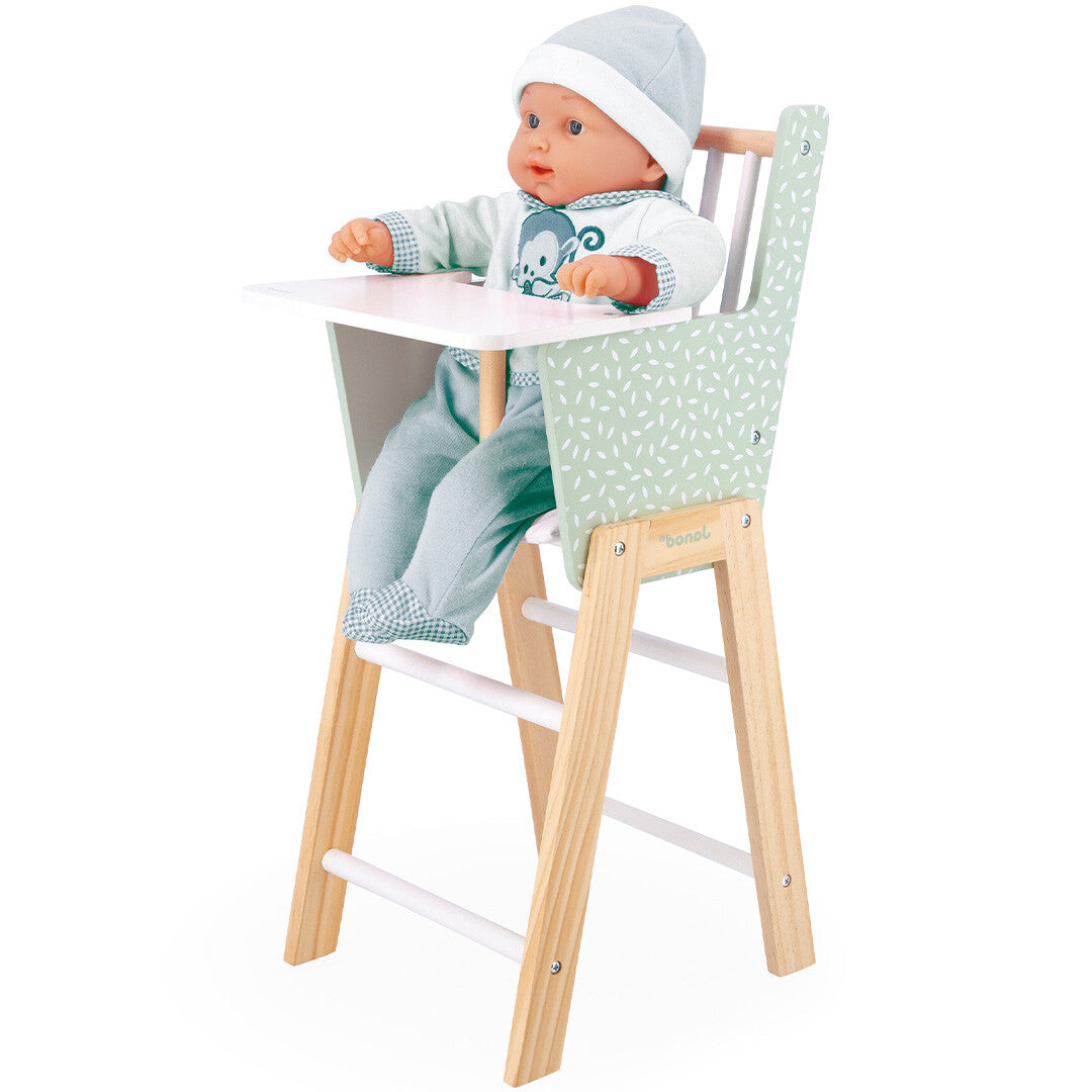 Janod poppenstoel met groen bladerenpatroon waarin een pop met blauwe kleding zit.