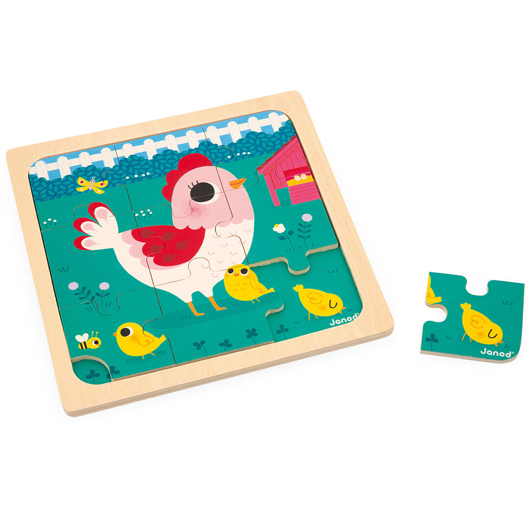 Janod houten puzzel met een kip en kuikens op een boerderij, met één los puzzelstuk ernaast.
