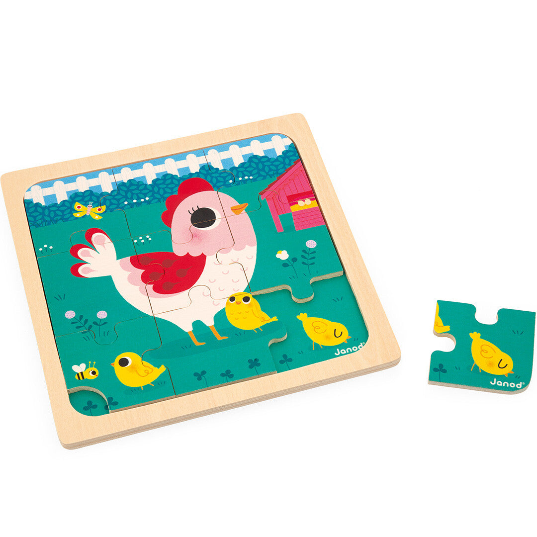 Janod houten puzzel met een afbeelding van een kip met kuikens op een boerderij, met één los puzzelstukje.