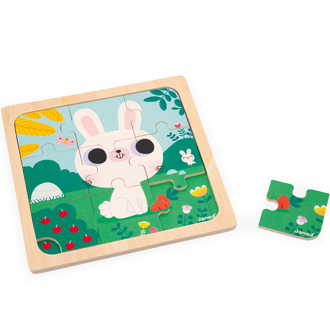 Janod houten puzzel met een afbeelding van een wit konijn in een tuin, met één los puzzelstukje.