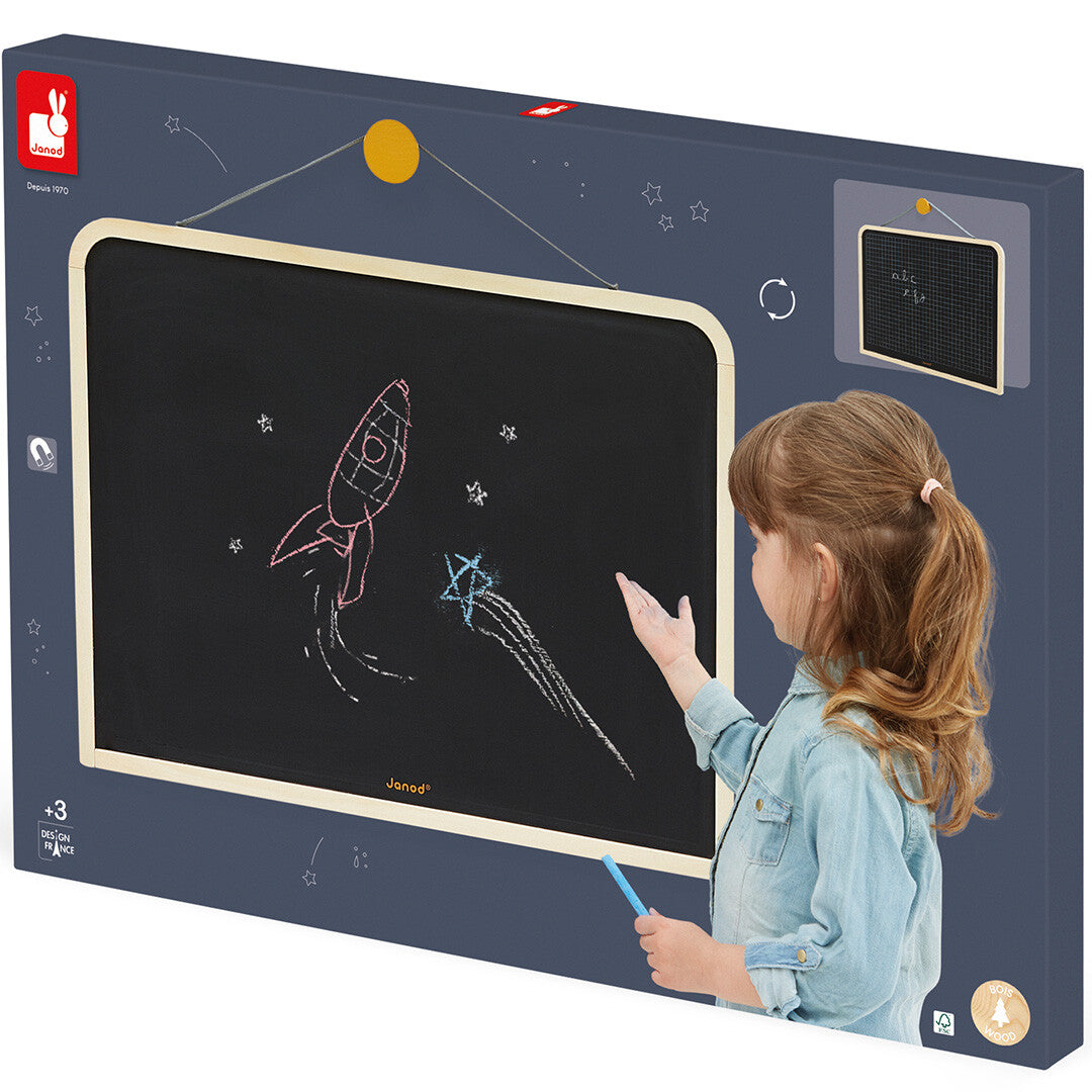 De verpakking van het Janod hangende schoolbord, met een afbeelding van een kind dat tekent op het bord.