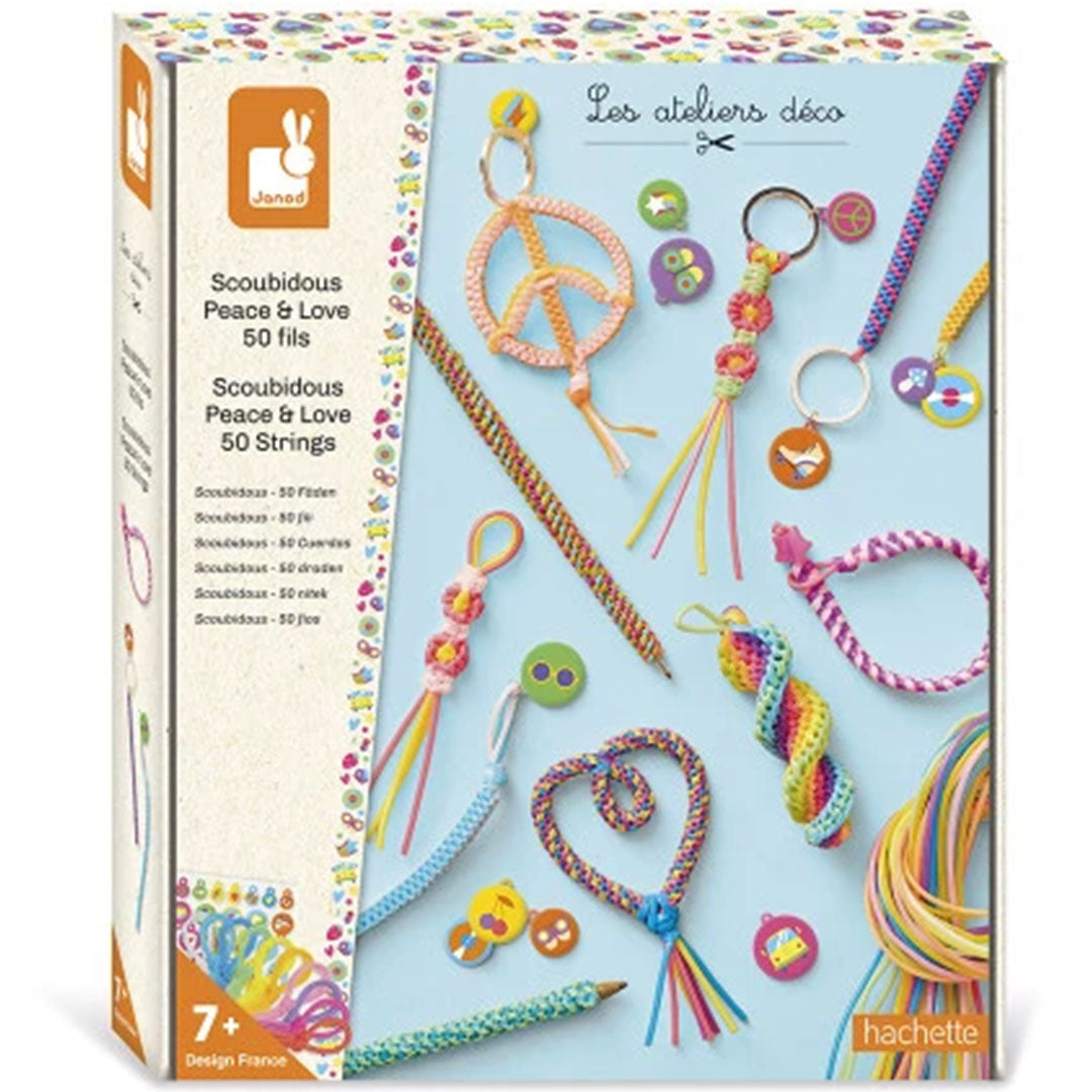 Janod Scoubidou Peace & Love hobbyset verpakking met voorbeelden van gemaakte sleutelhangers en armbanden.