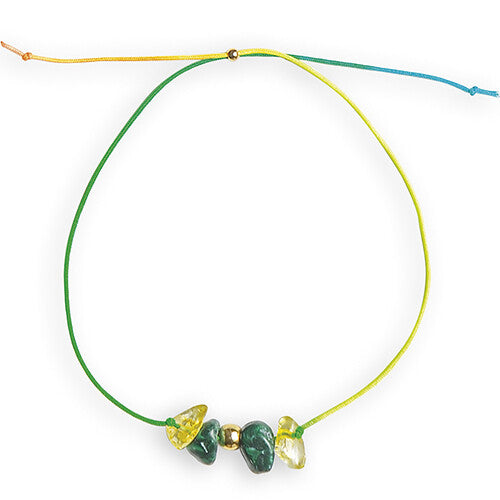 Detail van een armband met groene en gele geluksstenen en een gouden kraal aan een groen-geel koord.