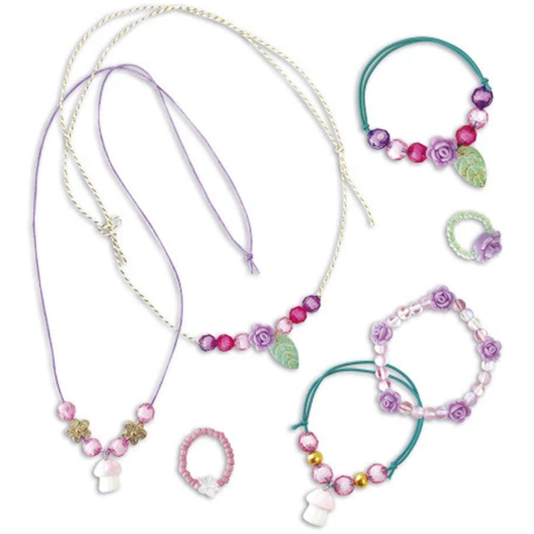 Collectie van gemaakte Janod Magic Fairies sieraden, waaronder kettingen, armbanden en ringen met bloemen en paddestoelen.