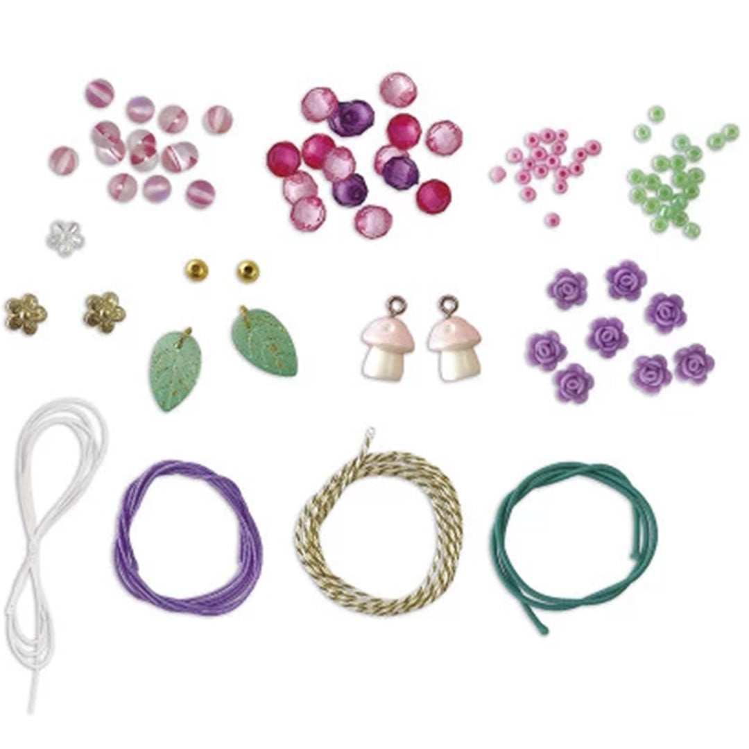 Detail van de Janod Magic Fairies sieraden maakset met losse kralen, bedeltjes en draden in verschillende kleuren.