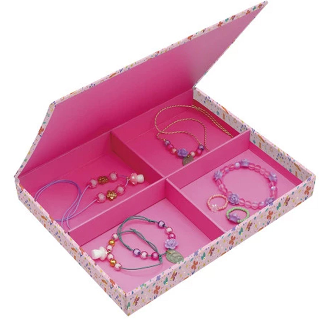 Open Janod Magic Fairies opbergdoos met roze vakken, gevuld met gemaakte kettingen en armbanden.