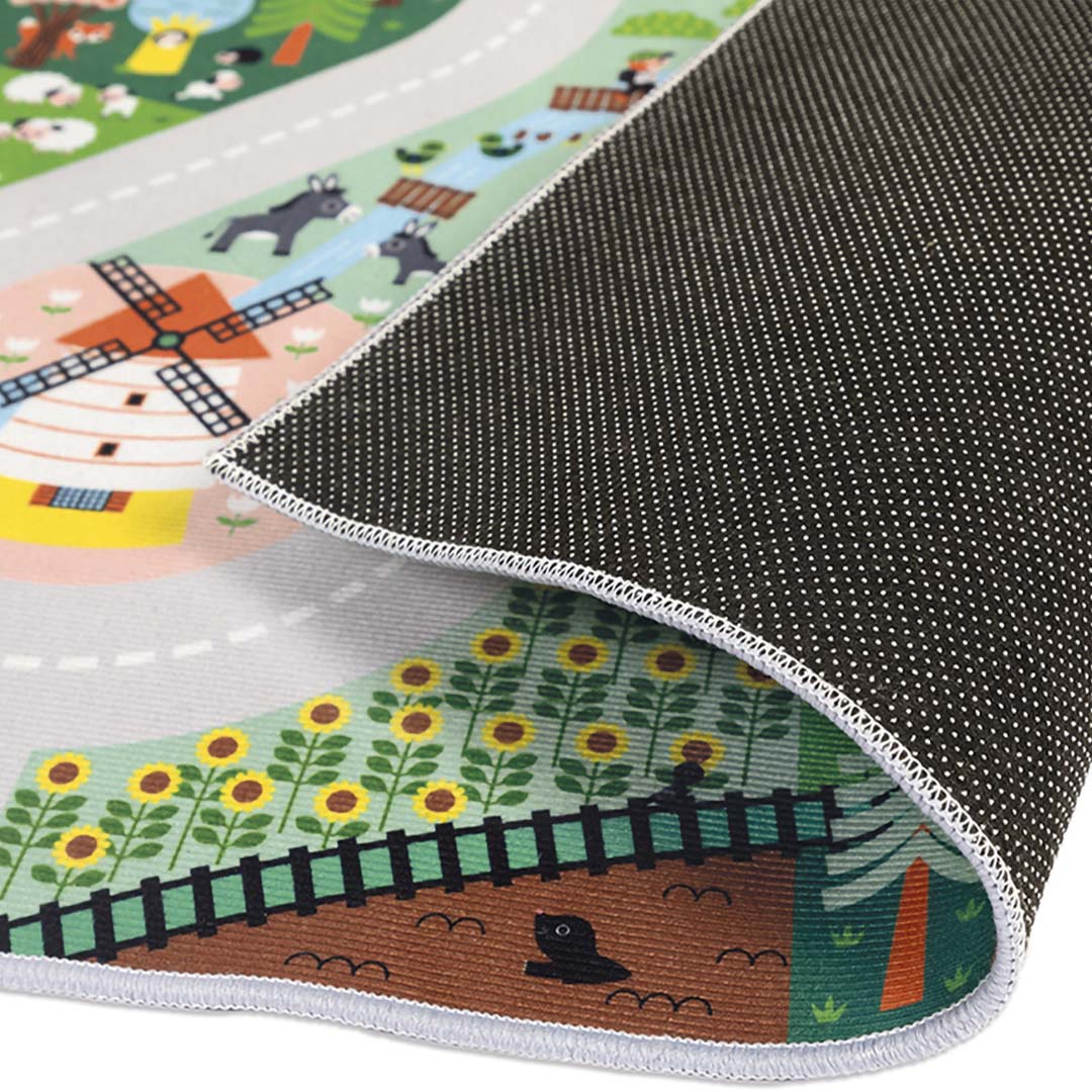 Detail van de onderkant van het Janod speelkleed 'Het Platteland' met antislip rubber en een opgerolde hoek.