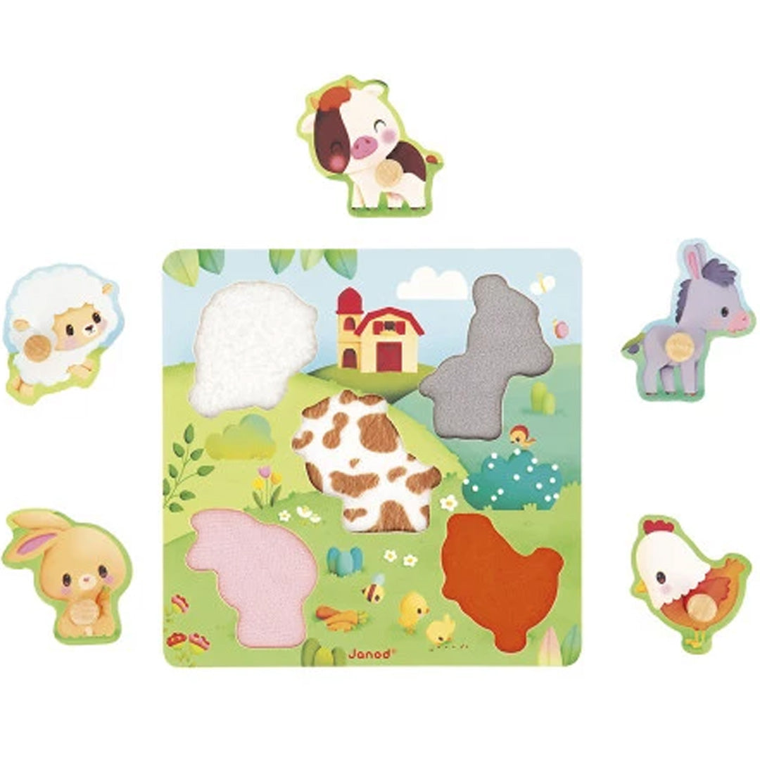 Janod houten voelpuzzel met boerderijdieren, waarbij de vijf puzzelstukken rondom het lege puzzelbord liggen.