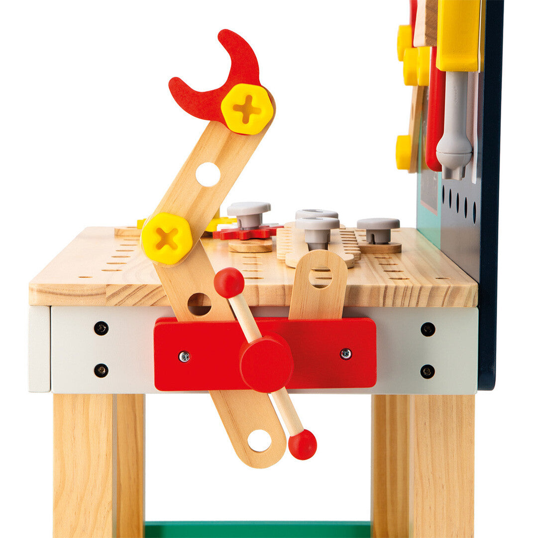 Detail van de houten werkbank met een rode bankschroef en houten onderdelen.