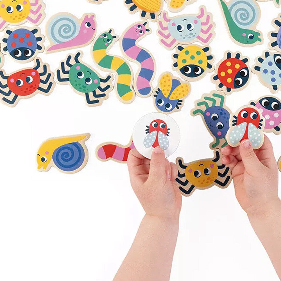 Kinderhanden spelen met de kleurrijke houten insecten en beestjes van het Janod zoekspel.