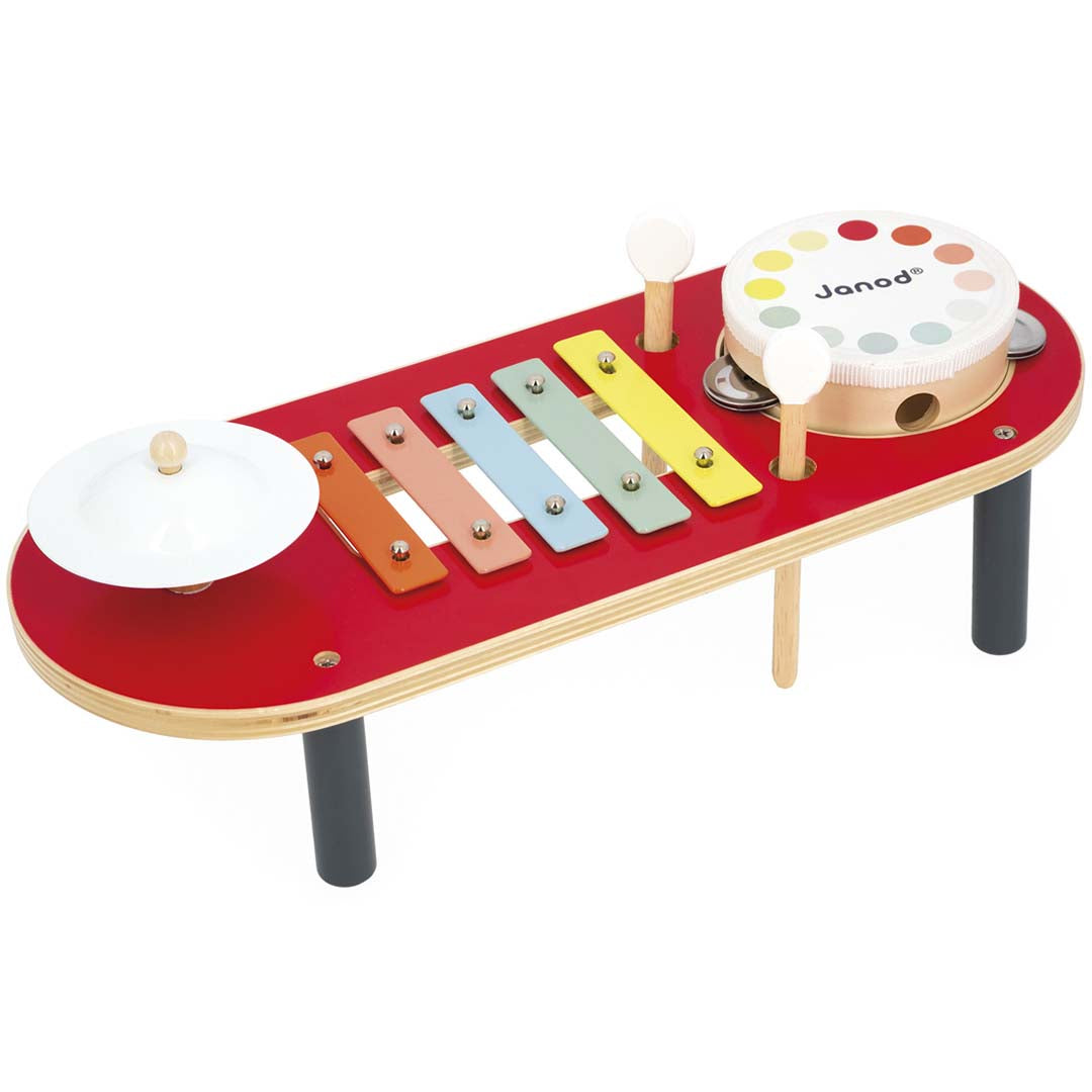 Janod houten muziektafel met rood blad, kleurrijke xylofoon, cymbaal en trommel.
