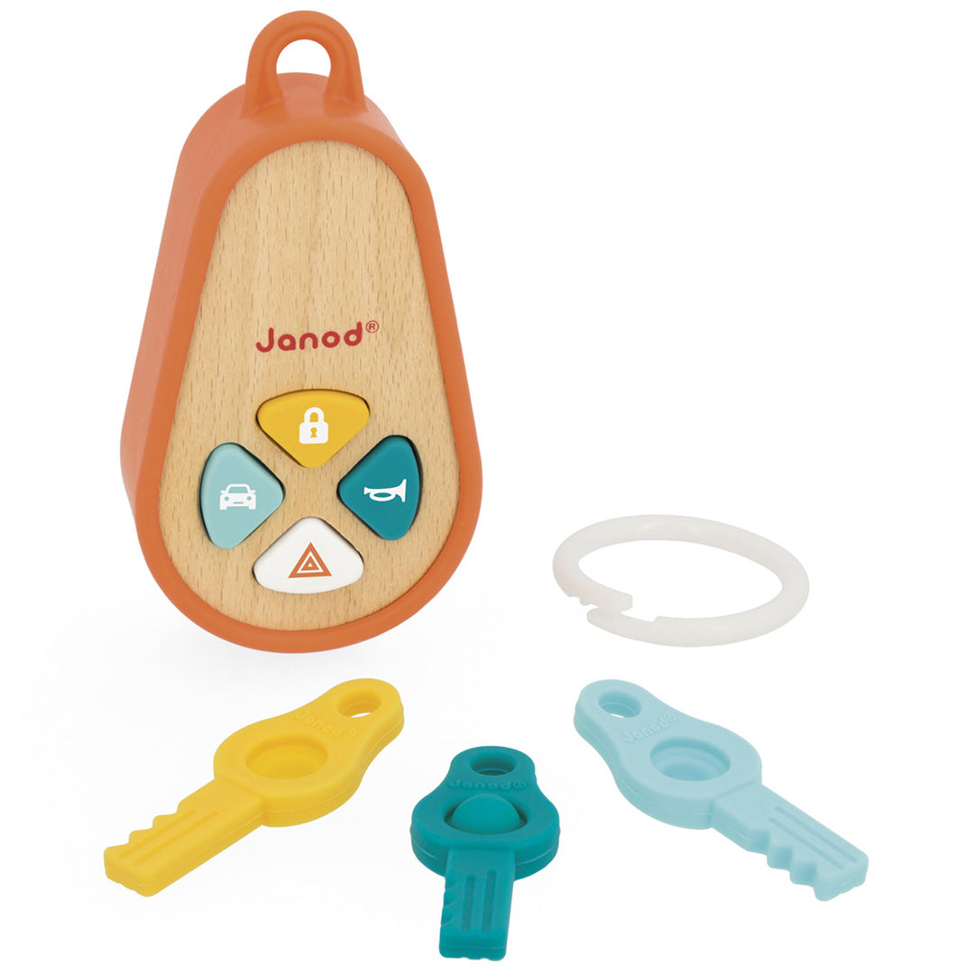 Het Janod houten activiteitenspeeltje sleutelhanger met geluid, met de losse gekleurde plastic sleutels en de witte ring ernaast.