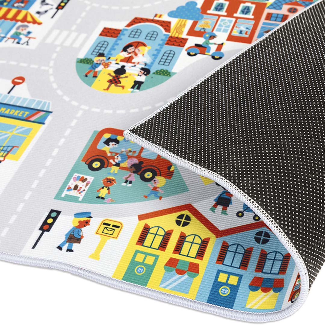 Detail van het Janod speelkleed 'De Stad' met een stukje stad en de zwarte antislip onderkant.