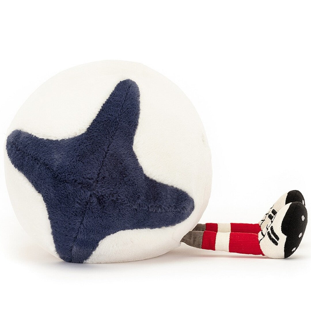 Zijaanzicht van de Jellycat amuseables knuffel rugbybal met donkerblauwe vlakken en gestreepte beentjes.