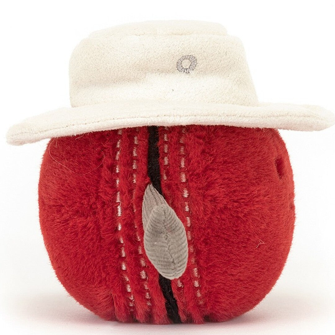 De achterkant van de Jellycat amuseables knuffelbal cricket, met de kenmerkende stiksels en het witte hoedje.