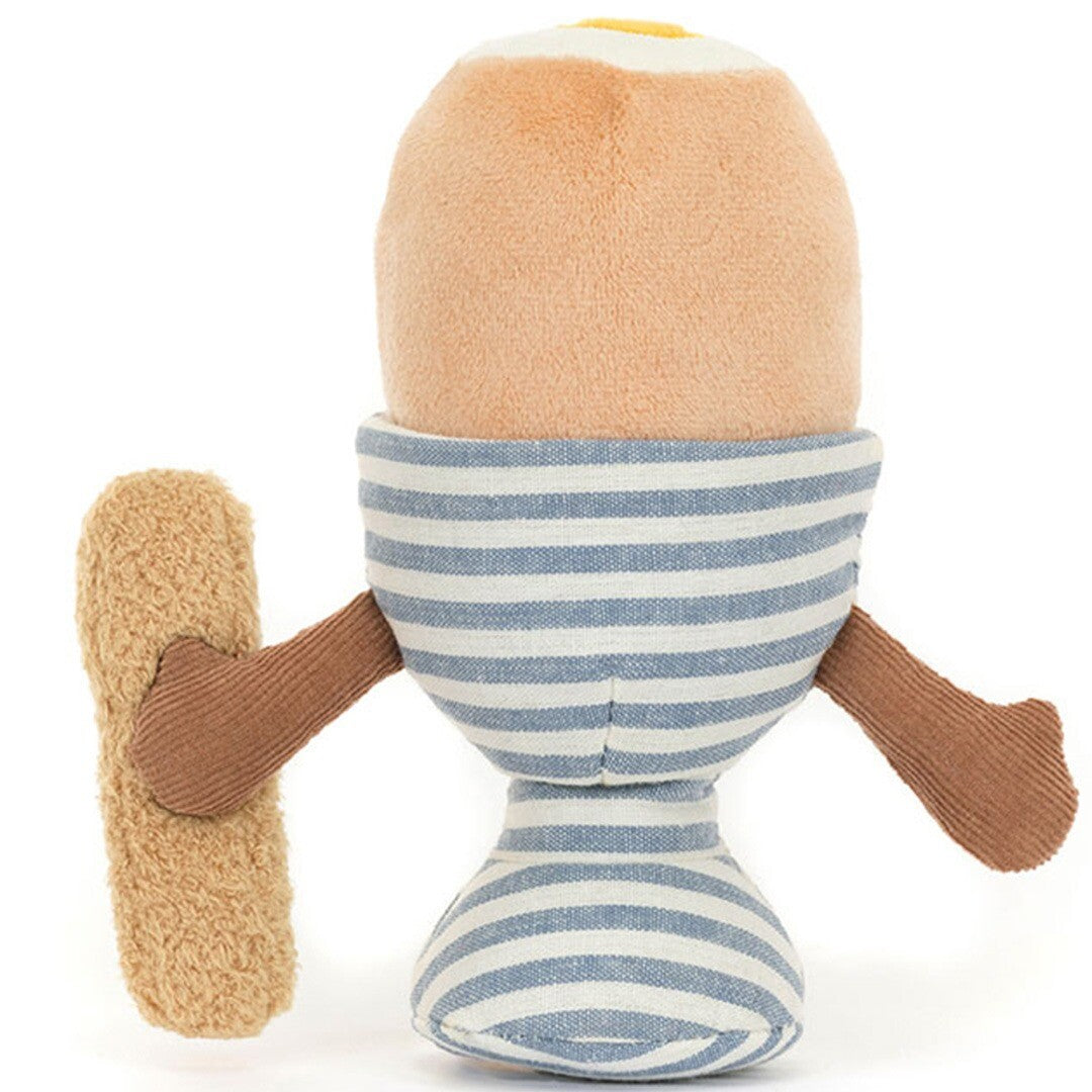 Jellycat knuffelei in gestreepte eierdop met knuffelsoldaatje, schuin van achteren gezien.