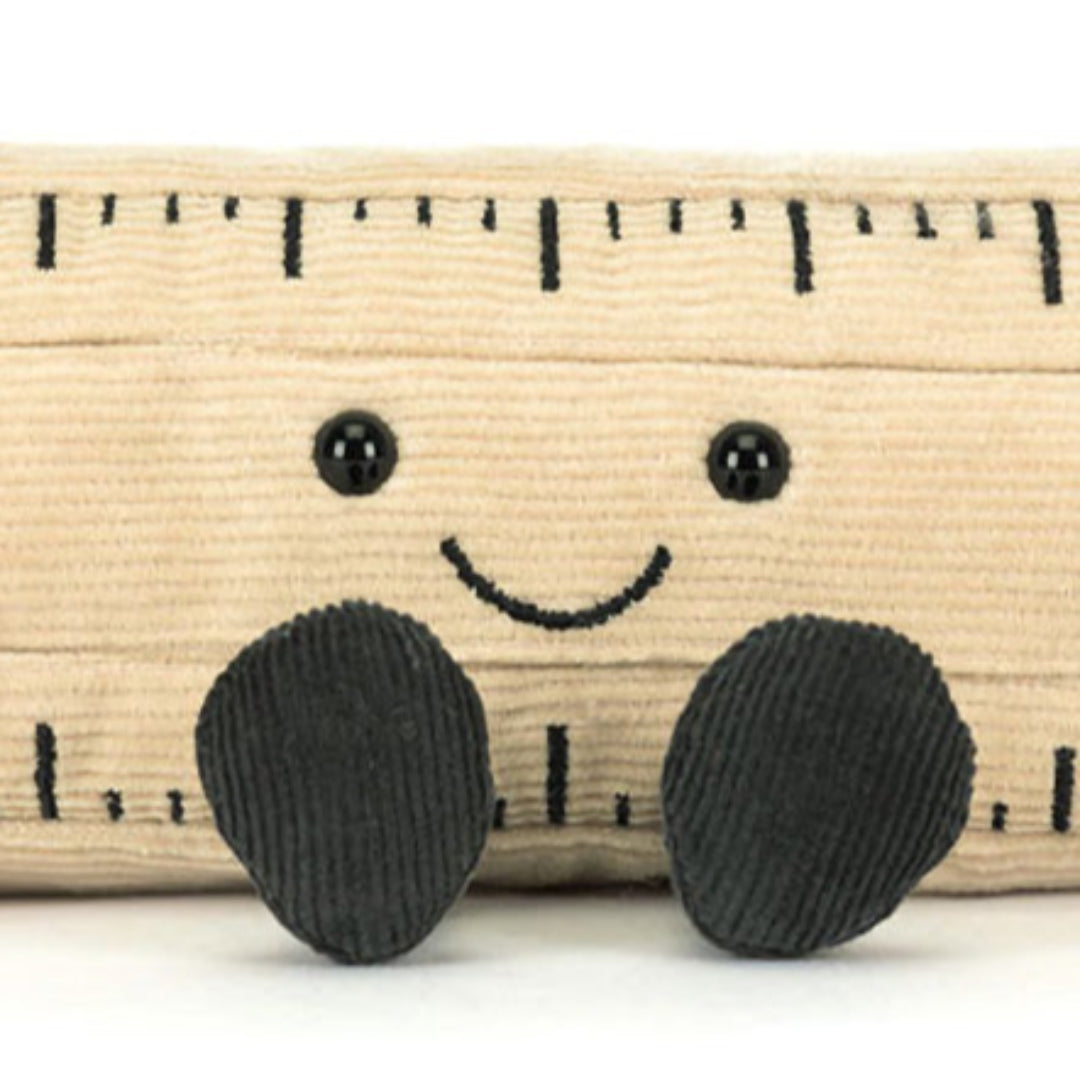 Detailopname van het vrolijke gezicht en de zwarte voetjes van de Jellycat pluchen knuffelliniaal.