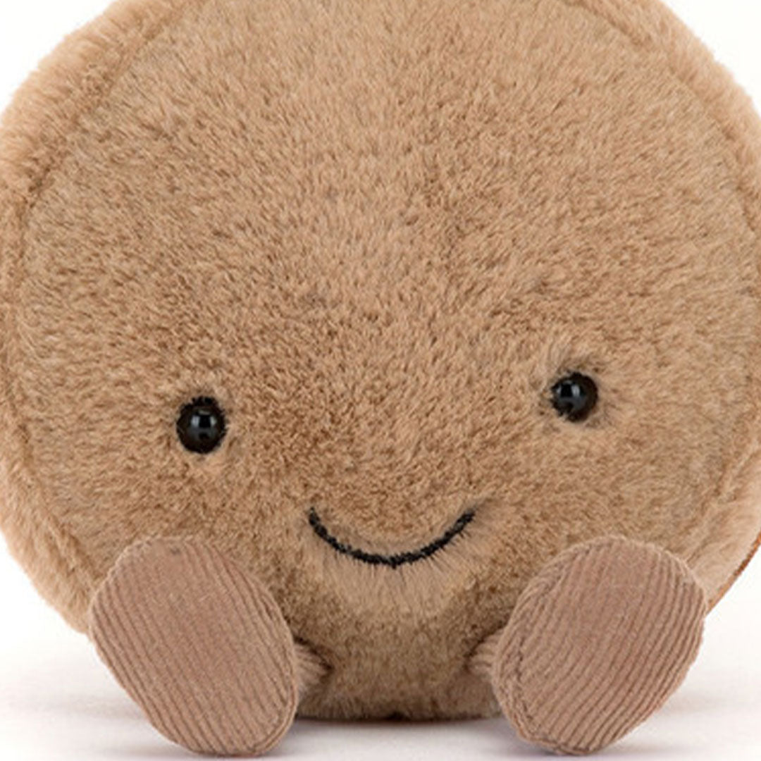 Close-up van het lachende gezicht van de Jellycat amuseables knuffelmacaron chocola.