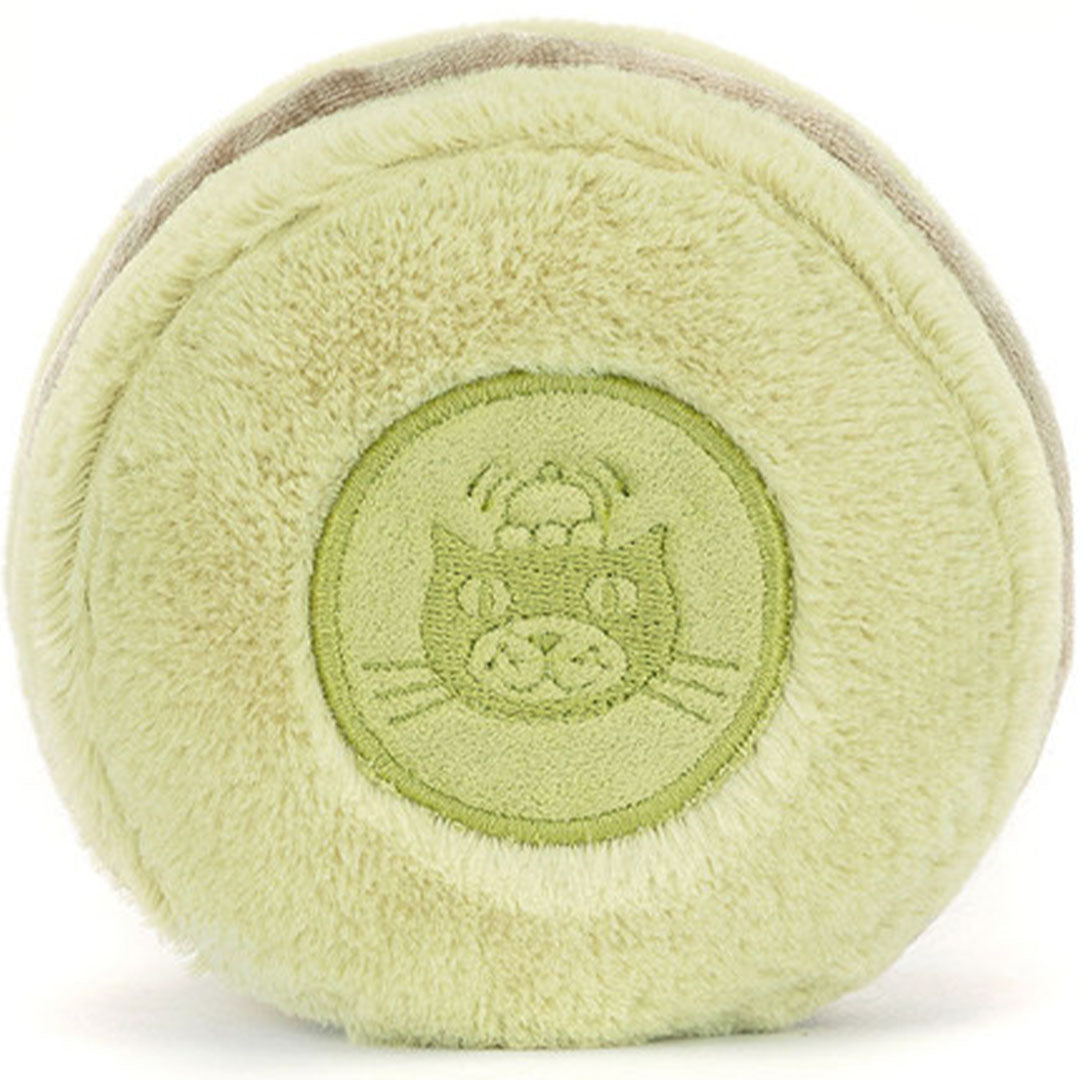 Achterkant van de Jellycat pluchen pistache macaron knuffel met een ingedrukt kattenlogo in het midden.