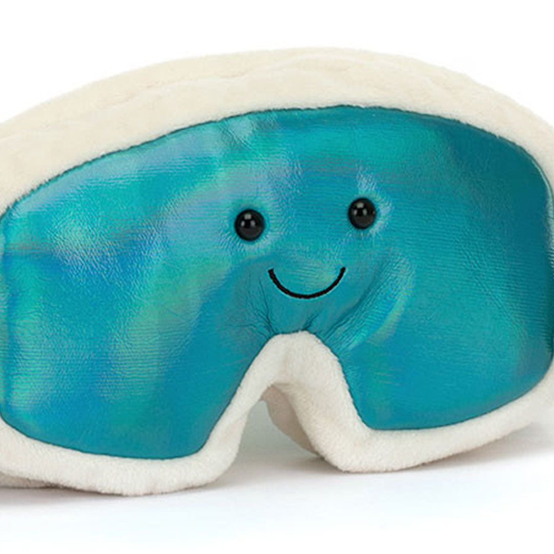 Detailopname van de voorkant van de Jellycat knuffelskibril met een lachend gezichtje op de glimmende blauwe lenzen.
