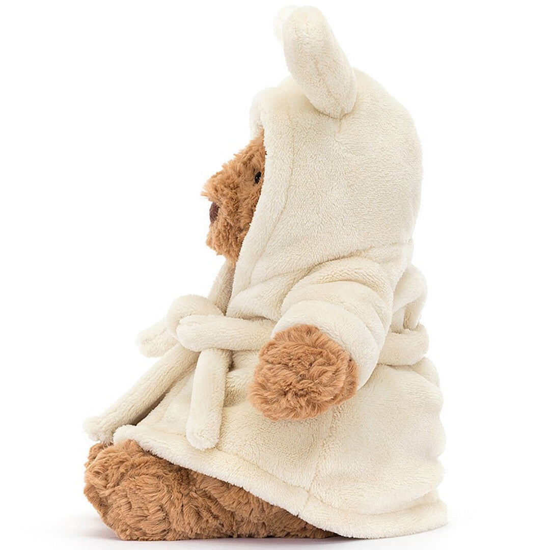 Zijaanzicht van de Jellycat knuffelbeer Bartholomew in een crèmekleurige badjas met konijnenoren.