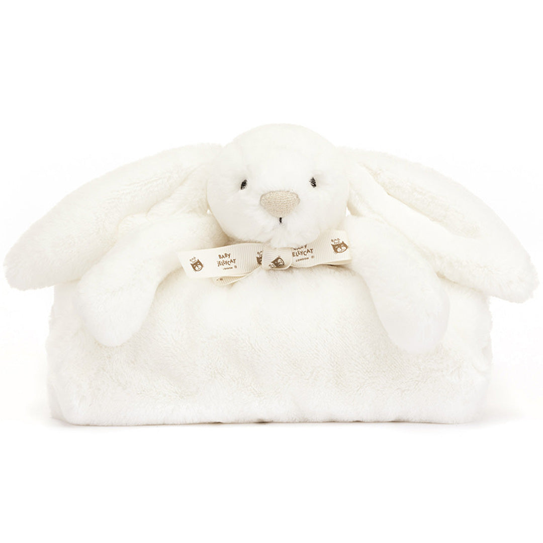 Jellycat knuffeldekentje bashful konijn, een wit pluchen konijnenhoofdje met armpjes en een lintje, bovenop een opgevouwen wit dekentje.