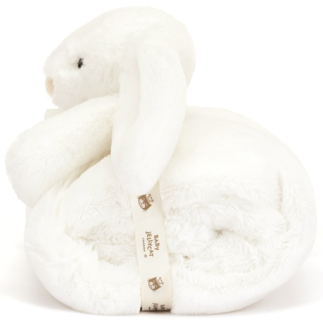 Zijaanzicht van het Baby Jellycat knuffeldekentje bashful konijn, opgerold met een lint eromheen en het konijnenhoofdje erbovenop.