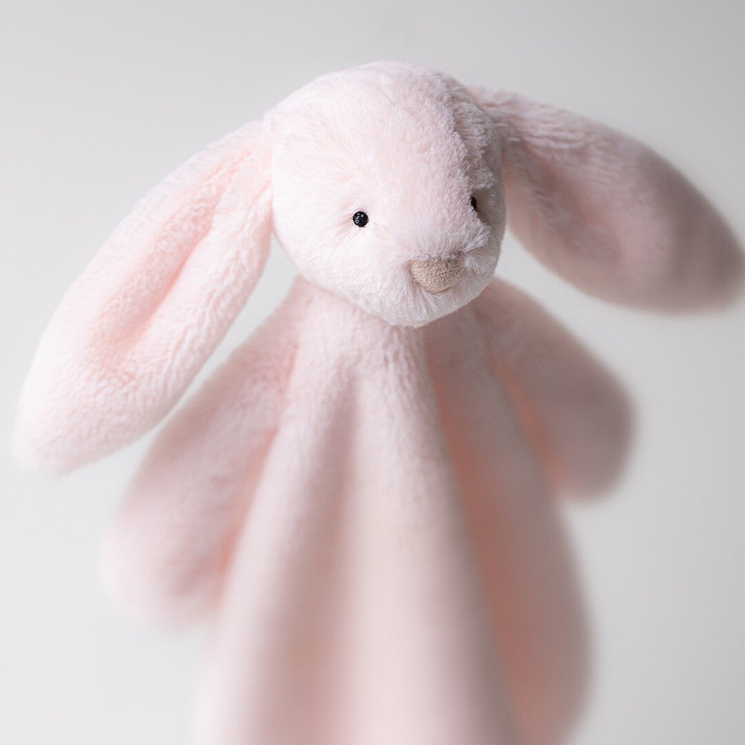 Close-up van de kop van de Jellycat roze konijn knuffeldoek, schuin van voren gefotografeerd.