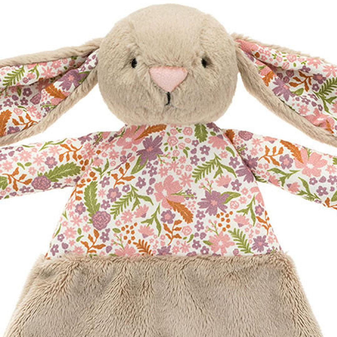 Detailopname van de kop en het gebloemde lijfje van de Jellycat pluchen konijnen knuffeldoek.