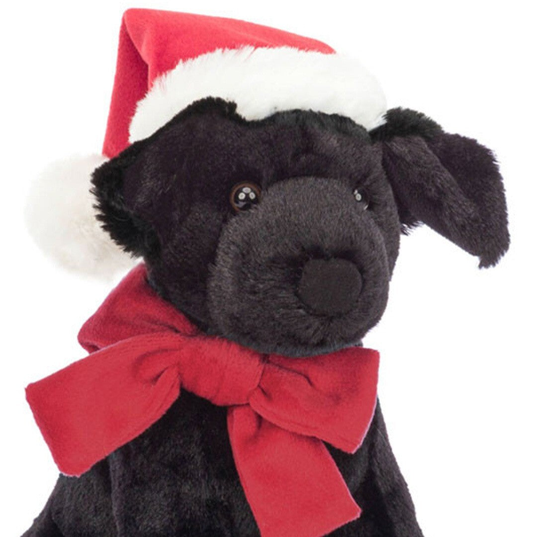 Detail van de kop van de Jellycat knuffelhond Pippa, met rode kerstmuts en rode strik.
