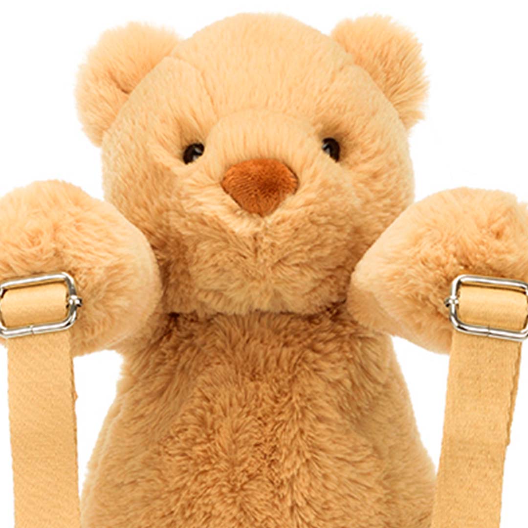 Close-up van het gezicht van de Jellycat peuterrugzak in de vorm van een lichtbruine knuffelbeer.
