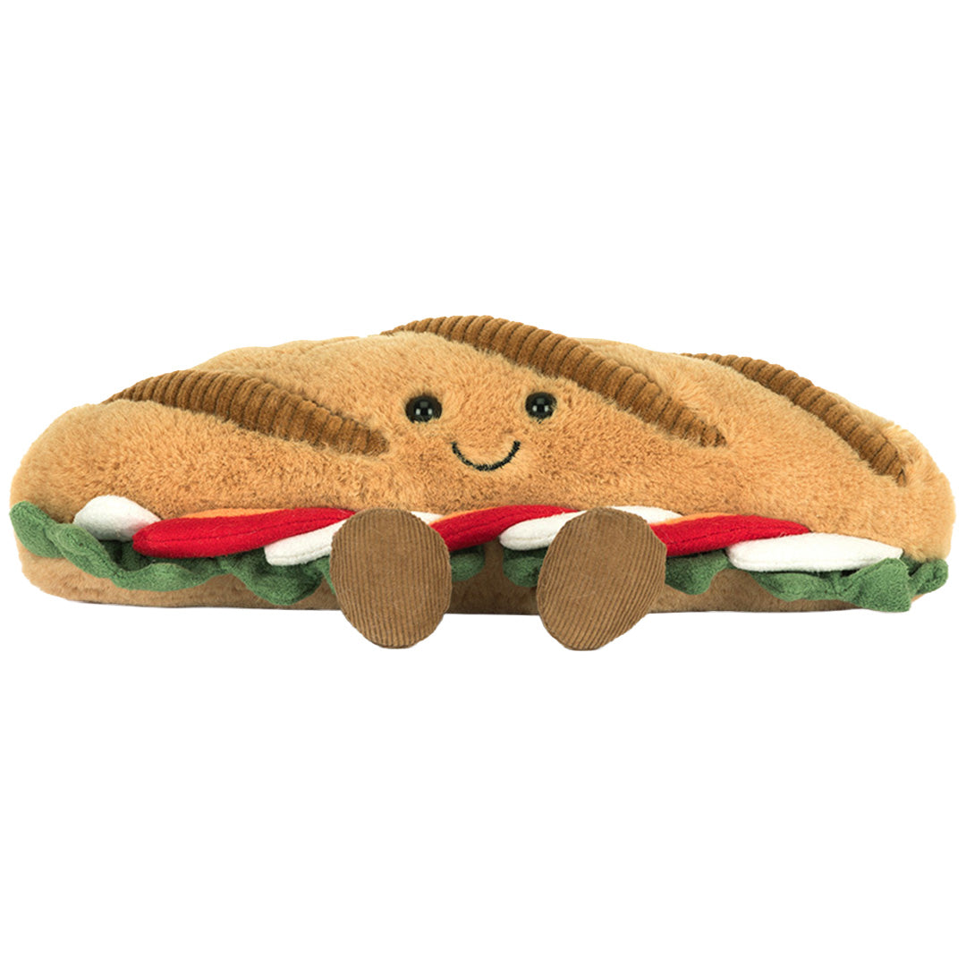 Jellycat pluchen baguette caprese knuffel met een lachend gezicht en kleine voetjes, van voren gezien.