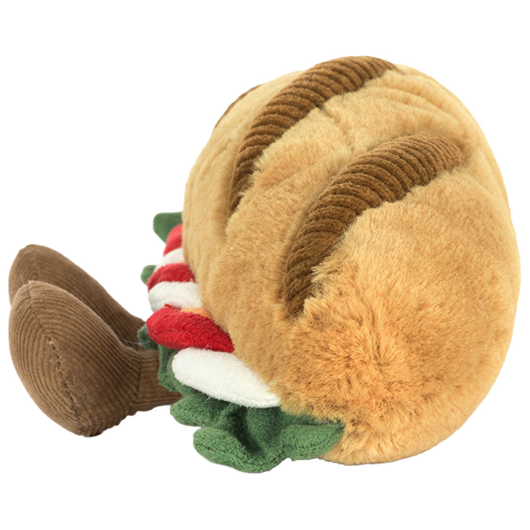 Zijaanzicht van de Jellycat pluchen baguette caprese knuffel, met de textuur van het brood en de vulling zichtbaar.