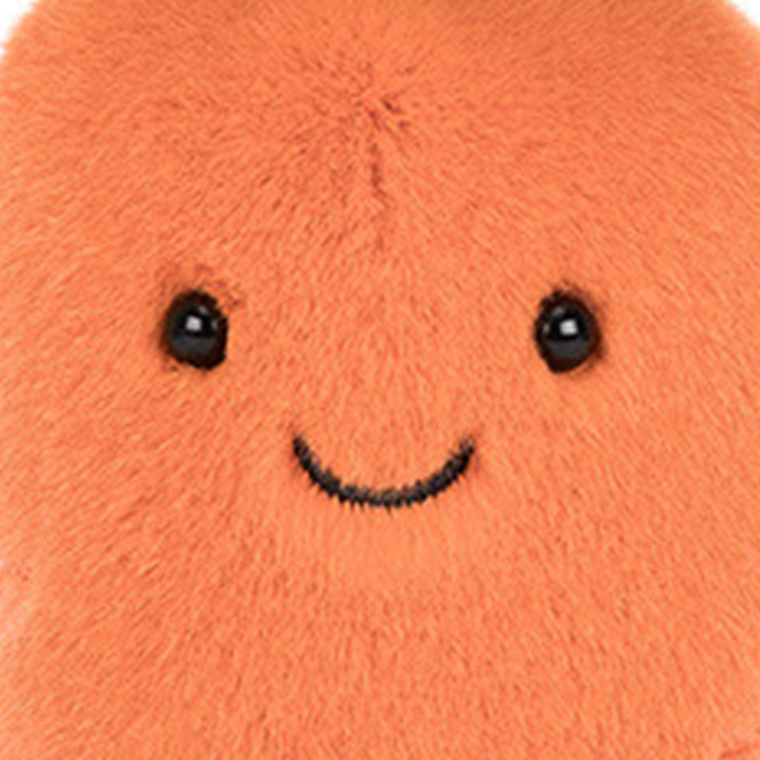 Close-up van het lachende gezicht van de Jellycat pluchen knuffelwortel.