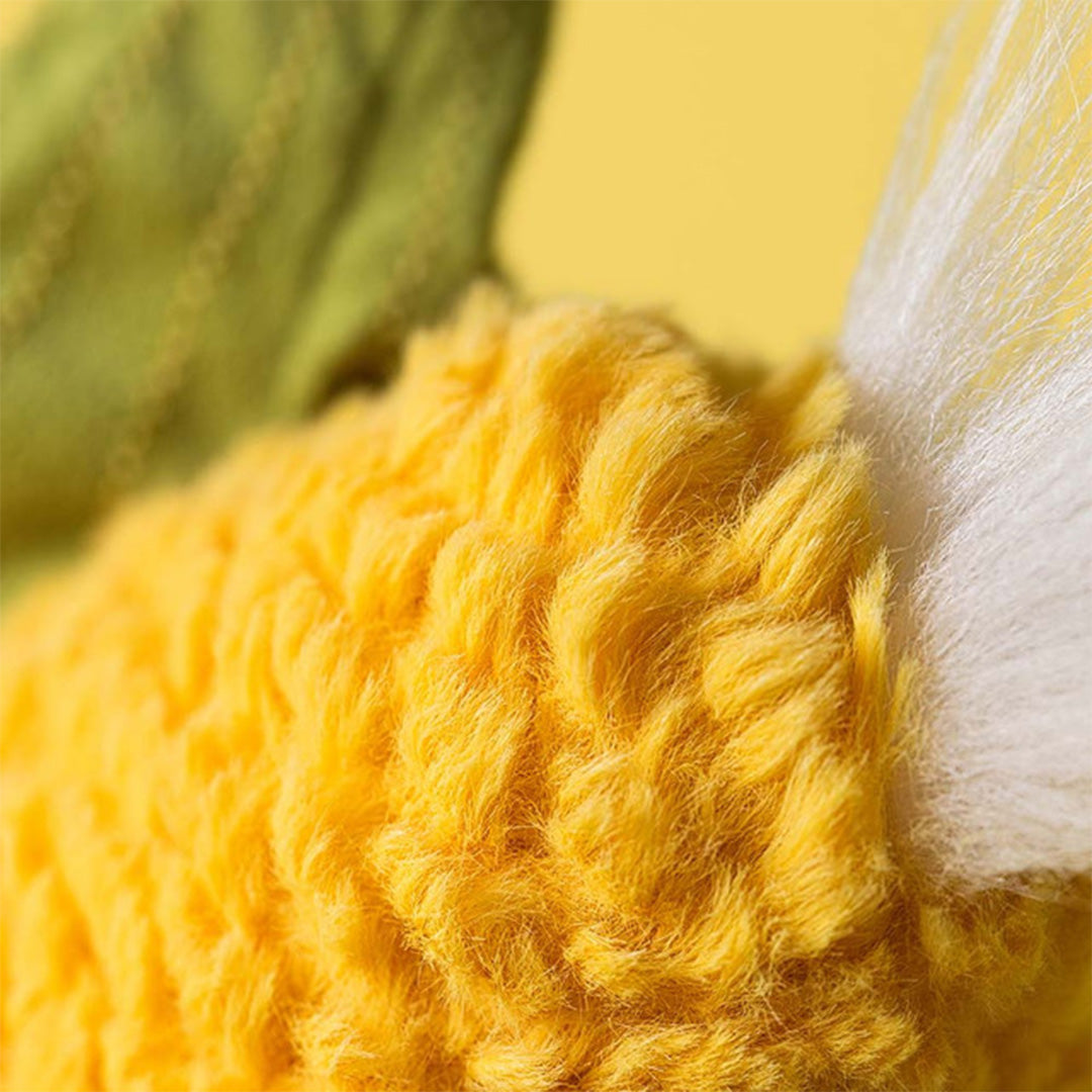 Detailopname van de pluizige gele textuur van de knuffelmaïs met witte pluimen.