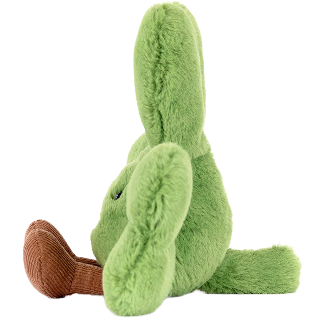 Zijaanzicht van het groene pluchen klavertje met bruine voetjes, zittend.