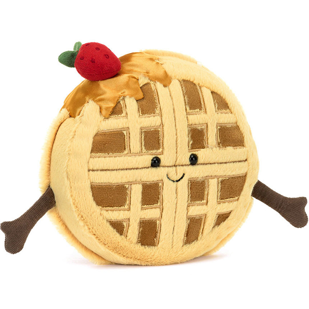 Jellycat amuseables knuffelwafel Rene met een vrolijk gezicht en een aardbei op de bovenkant, schuin gefotografeerd.