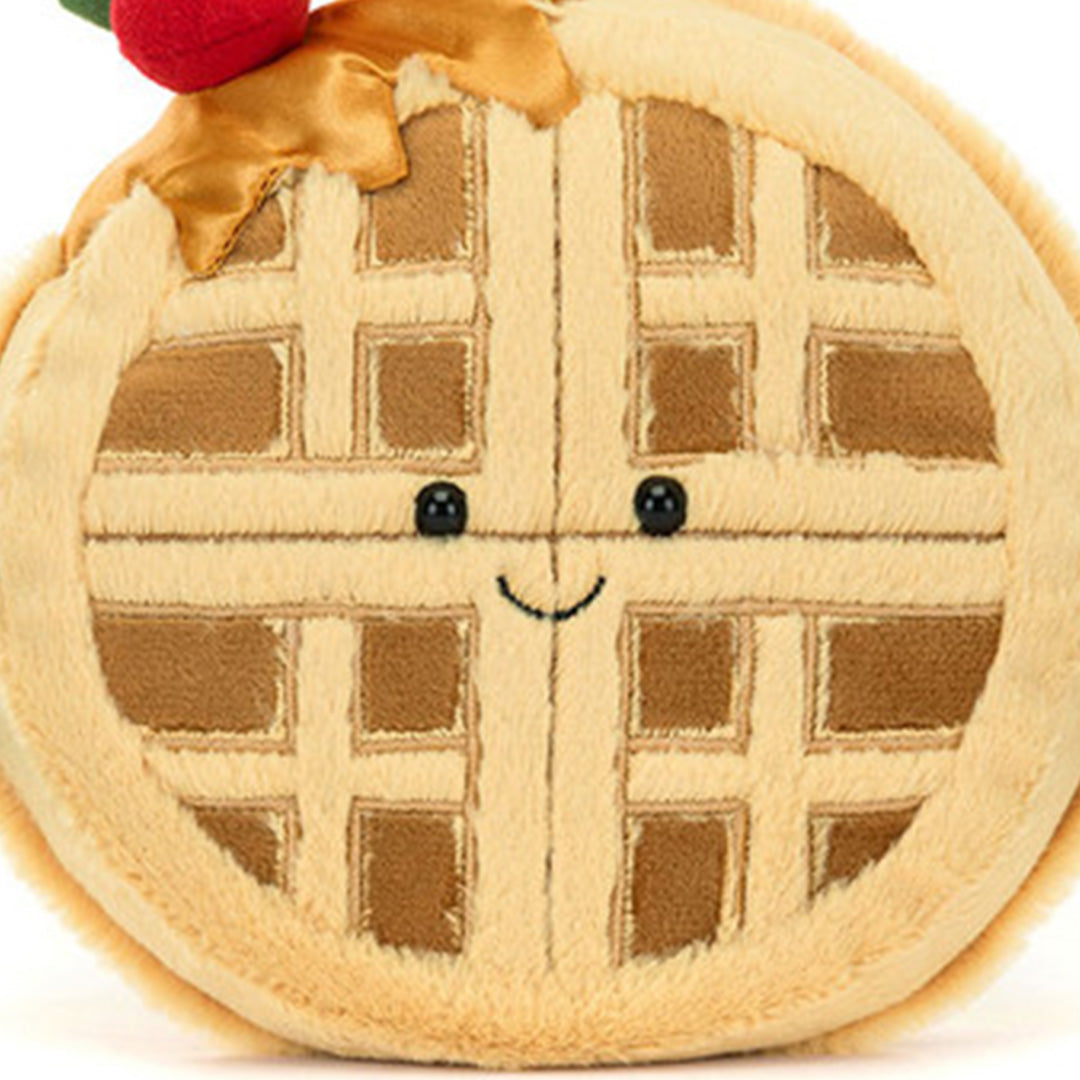 Detailopname van het vrolijke gezicht van de knuffelwafel Rene met een aardbei.