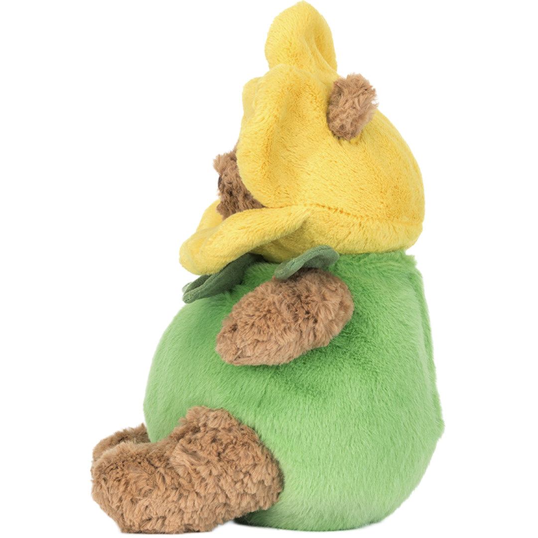 Pluchen knuffelbeer Bartholomew in narcispak, zittend en van de linkerkant gezien.