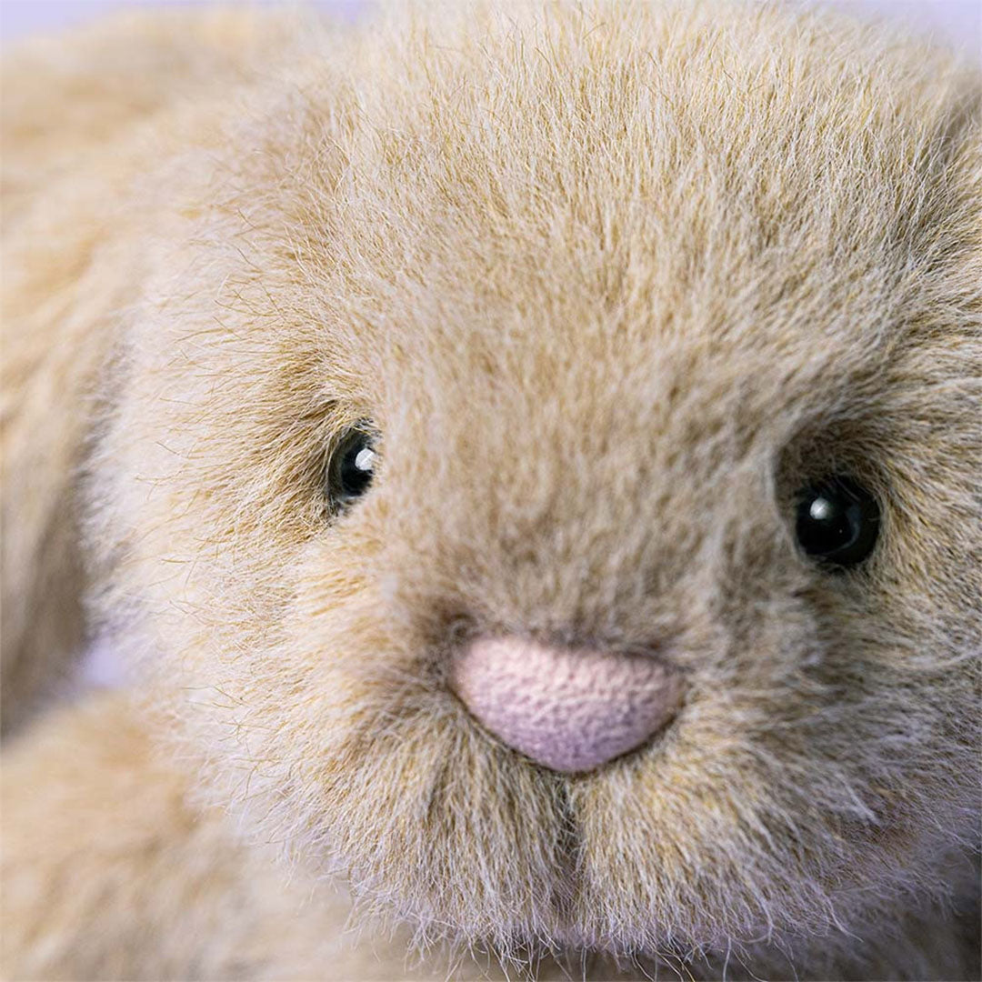 Close-up van het gezicht van het Jellycat pluchen knuffelkonijn met roze neus en zwarte ogen.