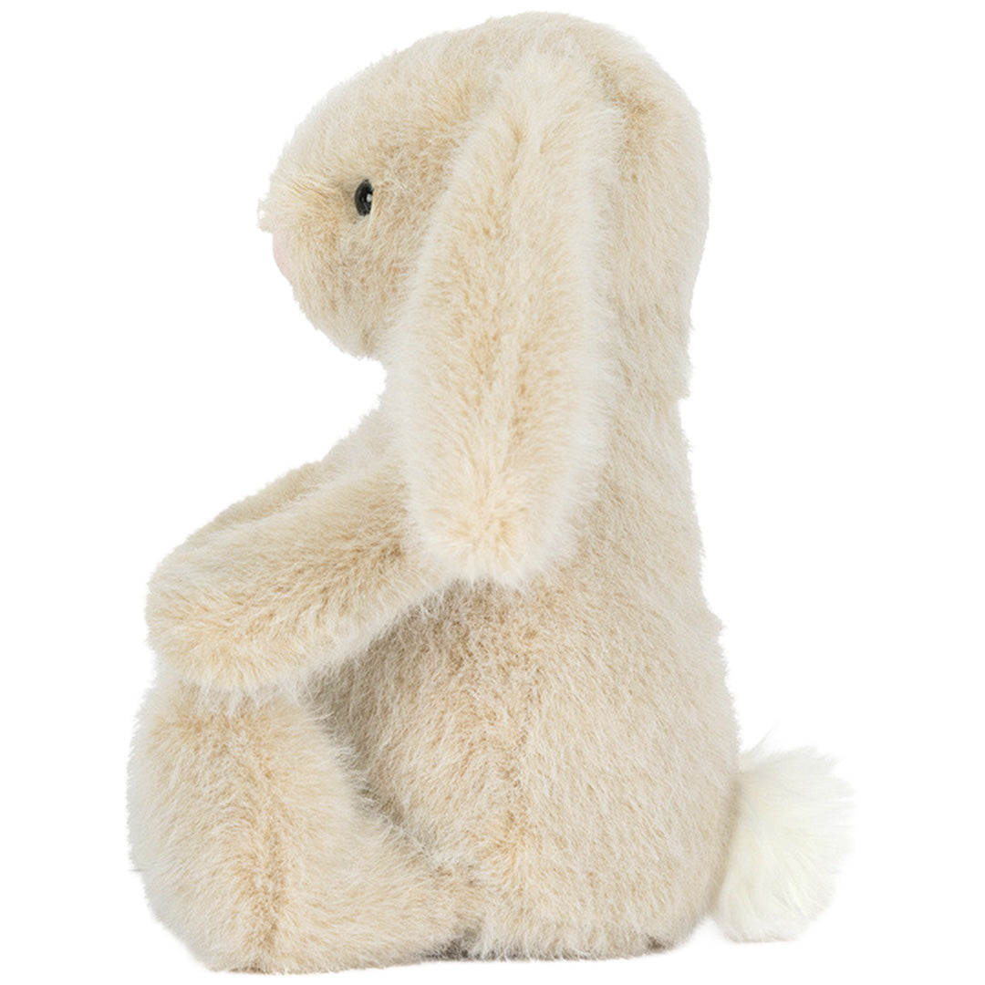 Zijaanzicht van de beige Jellycat Flufflet Bunny pluchen speelgoed, zittend met een pluizig staartje.