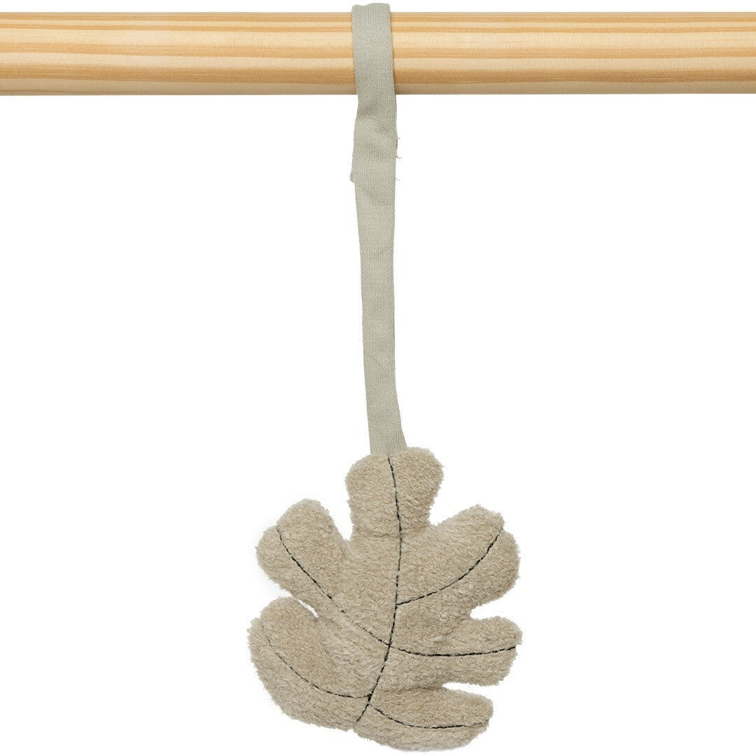 Close-up van het Jollein beige blad babygymspeeltje hangend aan een houten staaf.
