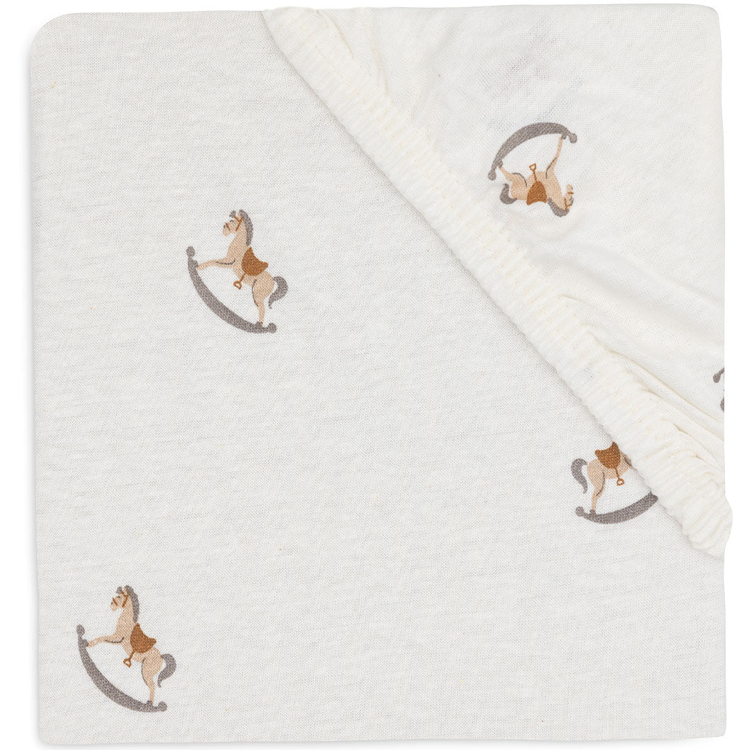 Jollein babyhoeslaken met beige wiebelpaardjespatroon, opgevouwen en van bovenaf gefotografeerd.