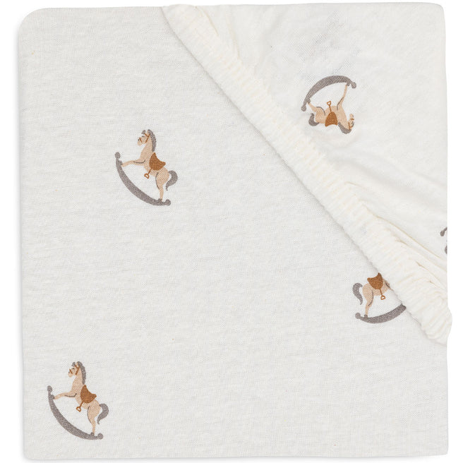 Jollein babyhoeslaken met beige wiebelpaardjespatroon, opgevouwen en van bovenaf gefotografeerd.