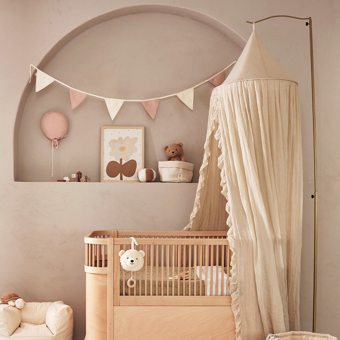 Jollein roze ballon decoratie hangend in een kinderkamer nis boven een babybedje.