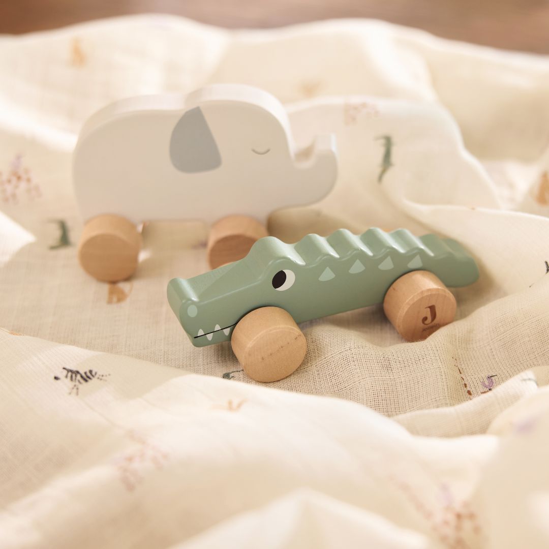 Jollein houten duwfiguur krokodil en een houten olifant op een lichtgekleurde doek.