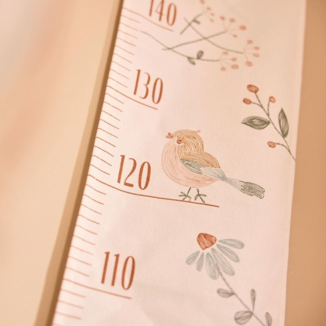 Detail van de Jollein groeimeter met een vogel en bloemen.