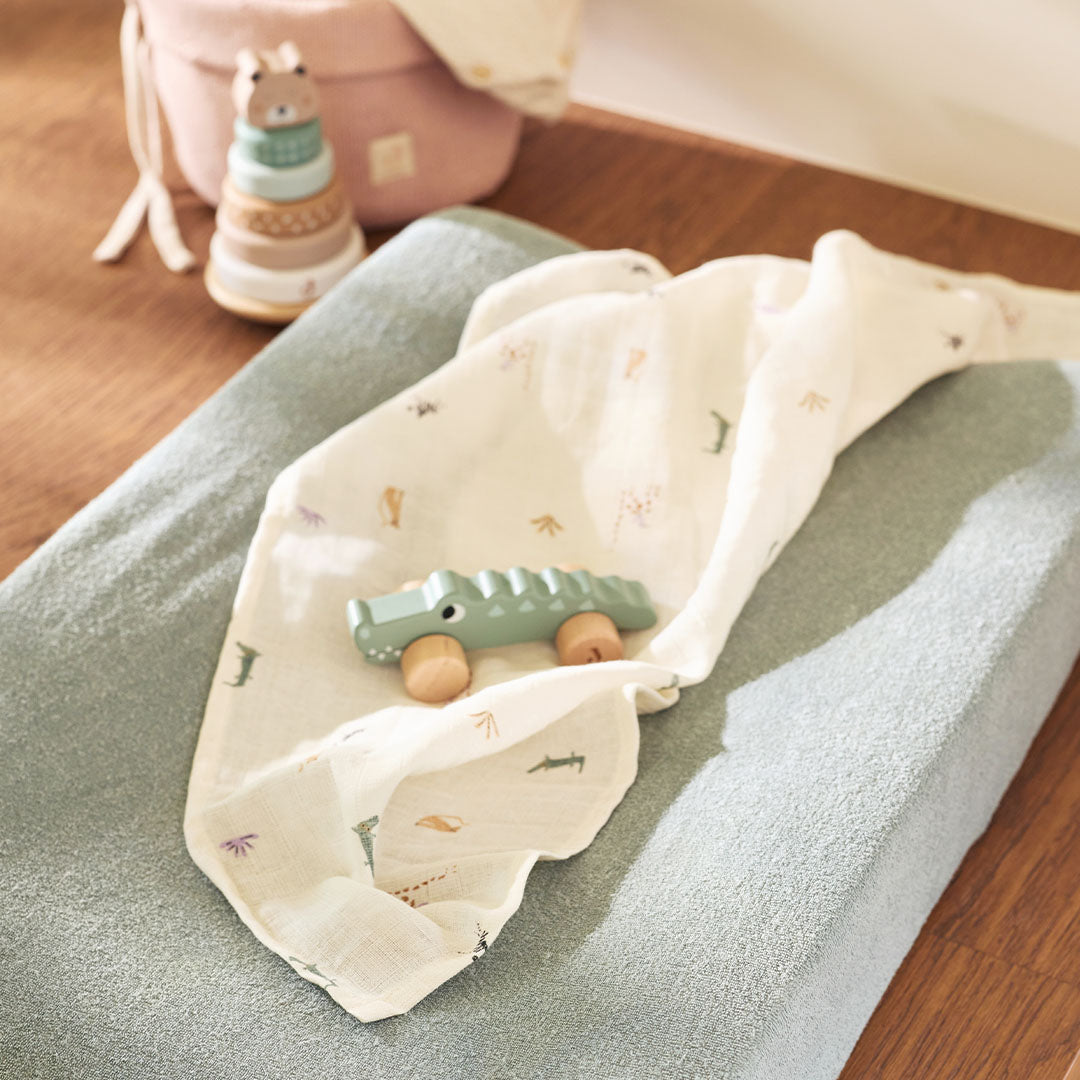 Jollein hydrofiele multidoek met jungle jambo print en een houten krokodil speelgoed op een aankleedkussen.