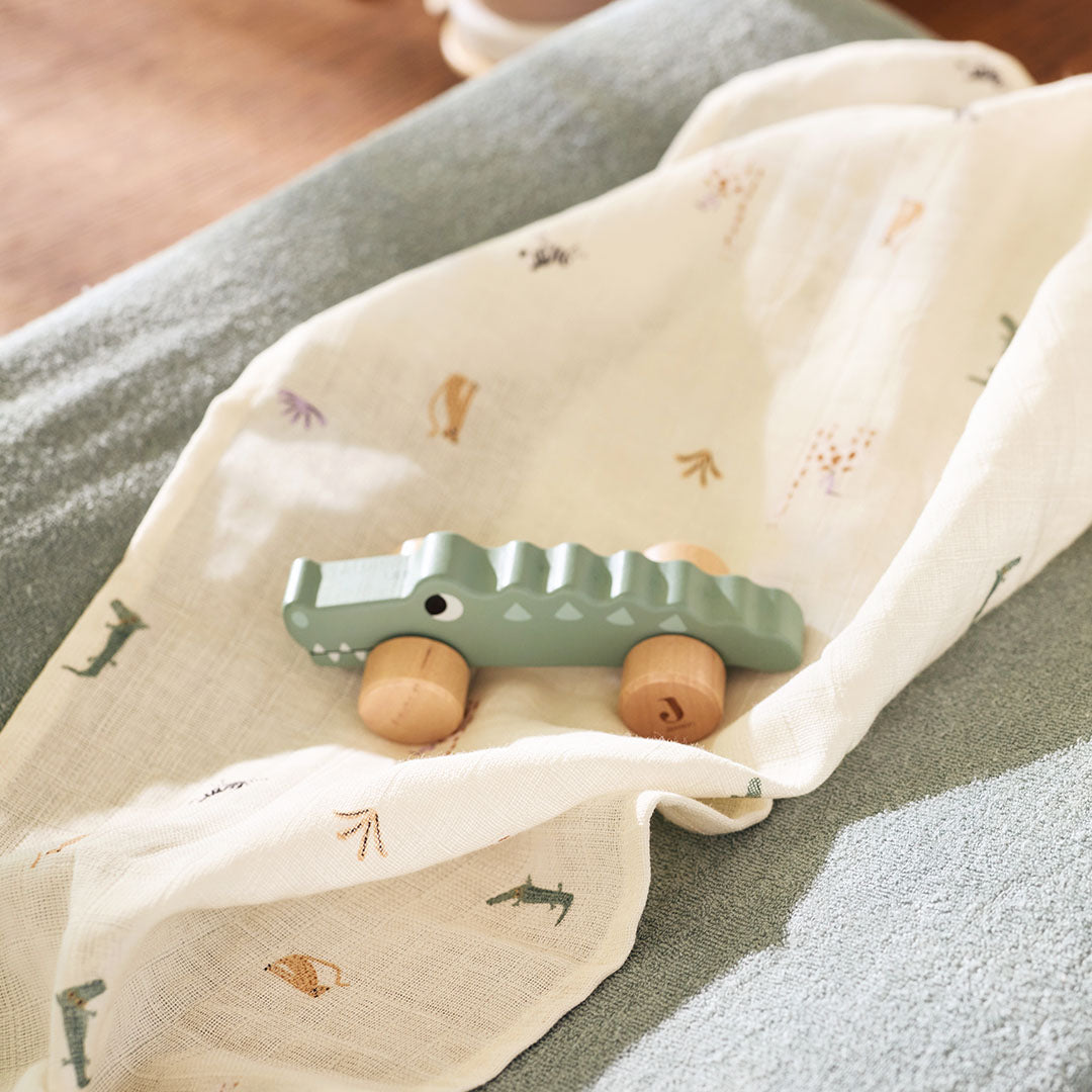 Detail van een Jollein hydrofiele multidoek met jungle jambo print en een houten krokodil speelgoed.